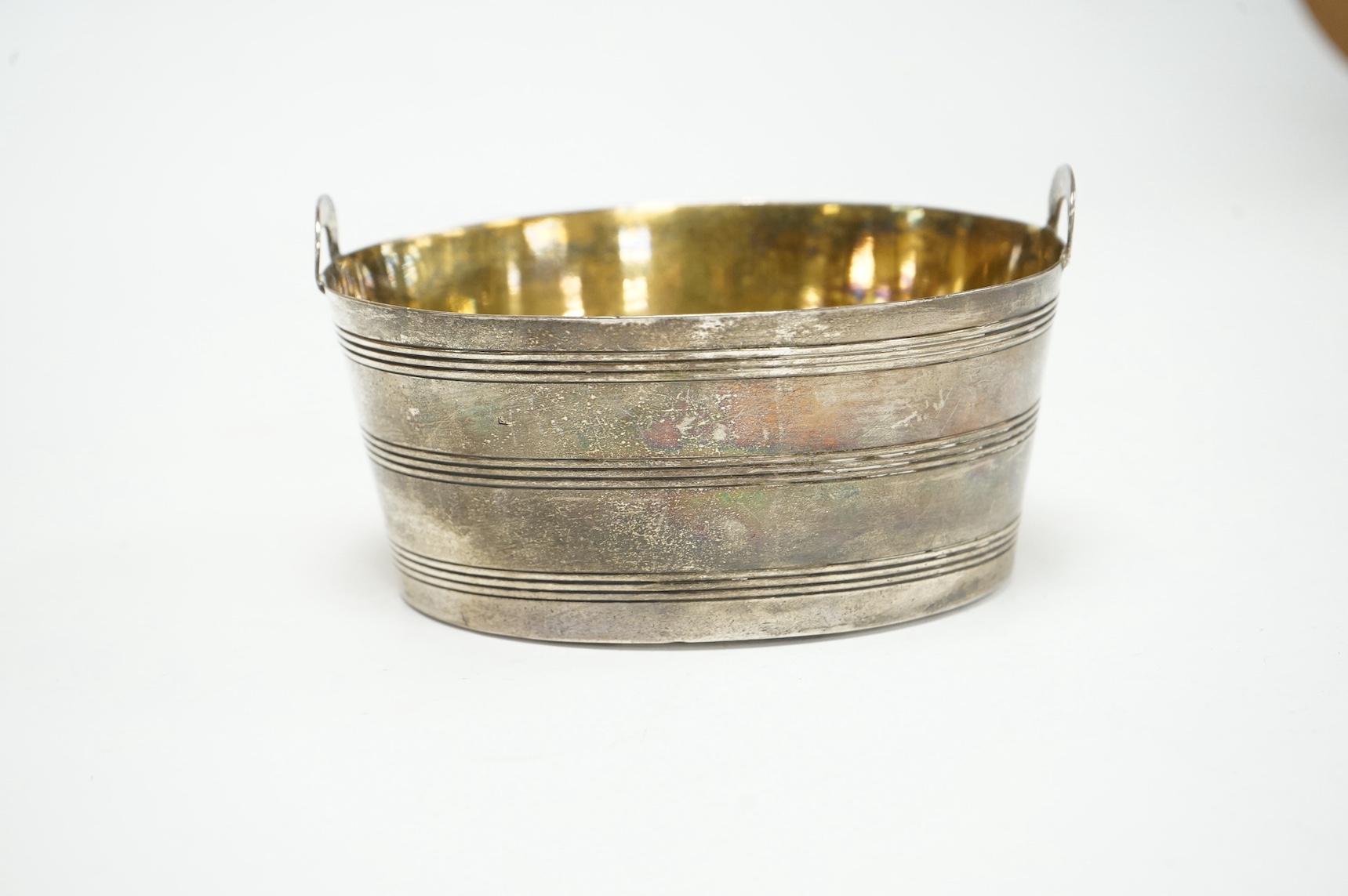 A George III silver two handled oval sugar bowl, of butter pail design, with reeded bands, maker S?, London, 1802, length 13.4cm, 7.3oz. Condition - poor to fair